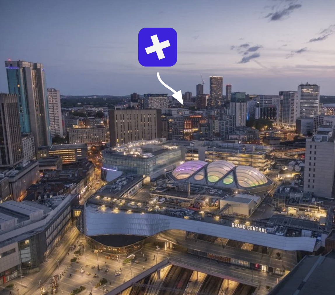 Birmingham city centre at dusk, looking across Grand Central and New Street station, with a Buried marker over the city