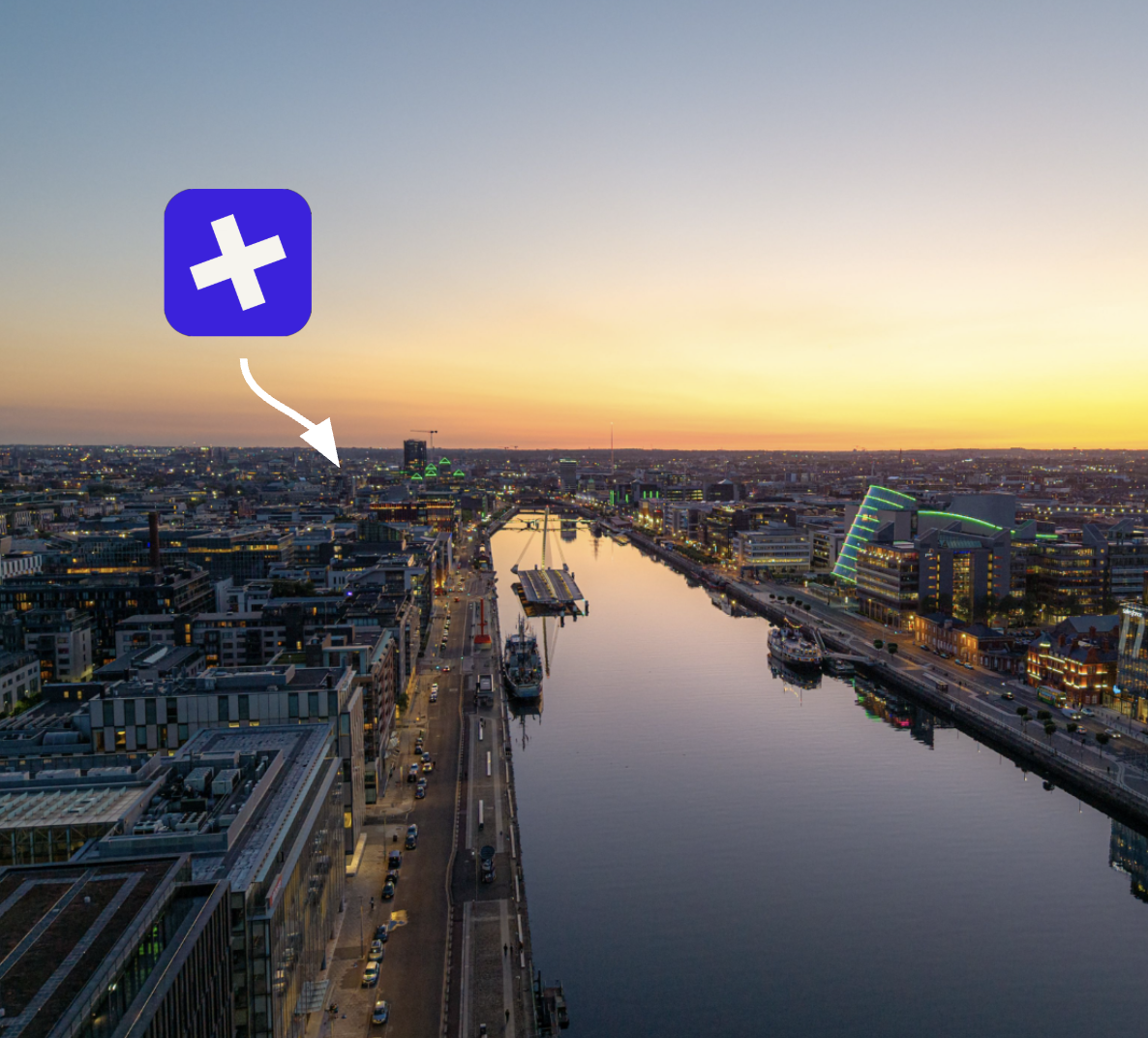 Dublin at sunset from above, looking down the River Liffey over the docklands and the Convention Centre, with a Buried marker over the city