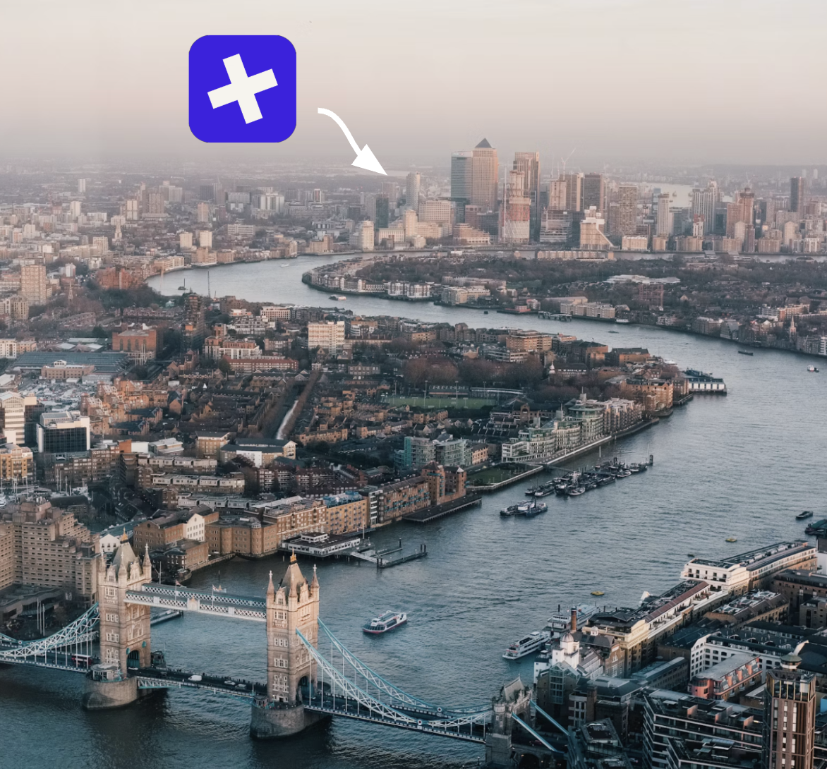 London at dusk from above, looking east along the Thames over Tower Bridge towards Canary Wharf, with a Buried marker over the city